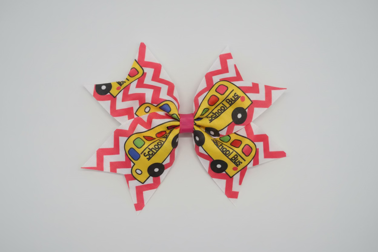 A large hair bow featuring a pink and white chevron pattern with yellow school bus illustrations, displayed on a white faux fur background.
